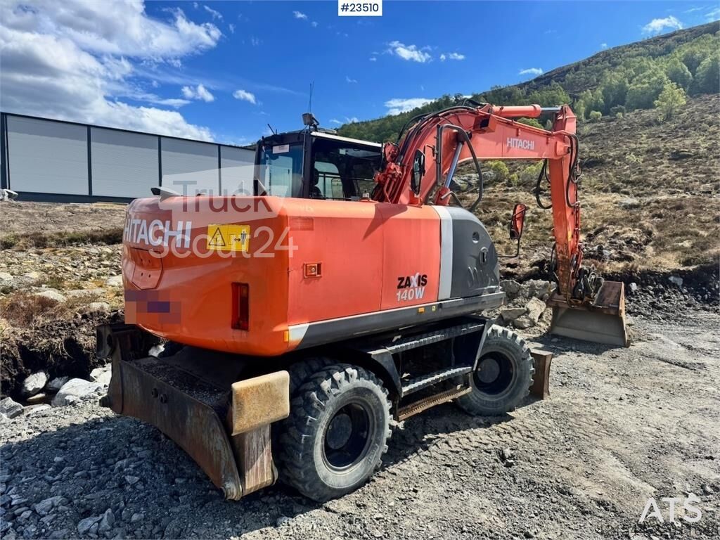 ⇒ Hitachi ZX140W-3 wheel excavator with Rototilt and grading