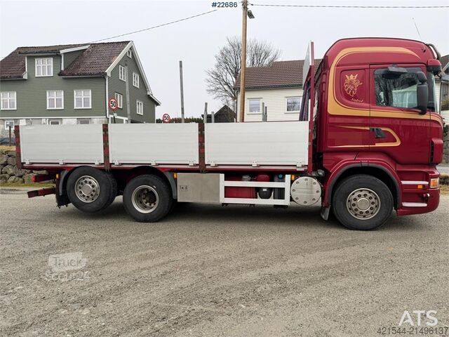 Platformos priekaba Scania R560 6x2 flatbed truck with setup for a rear-mount