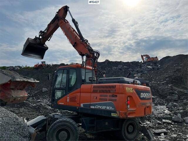 Other Doosan DX210 W w/ Grader blade & Outriggers WATCH
